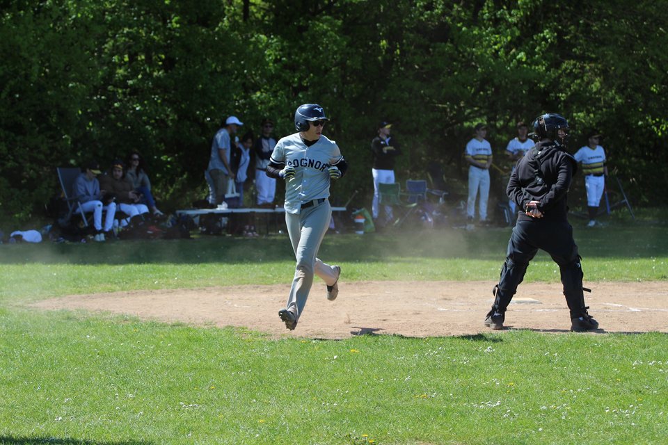 Baseball player running towards home plate